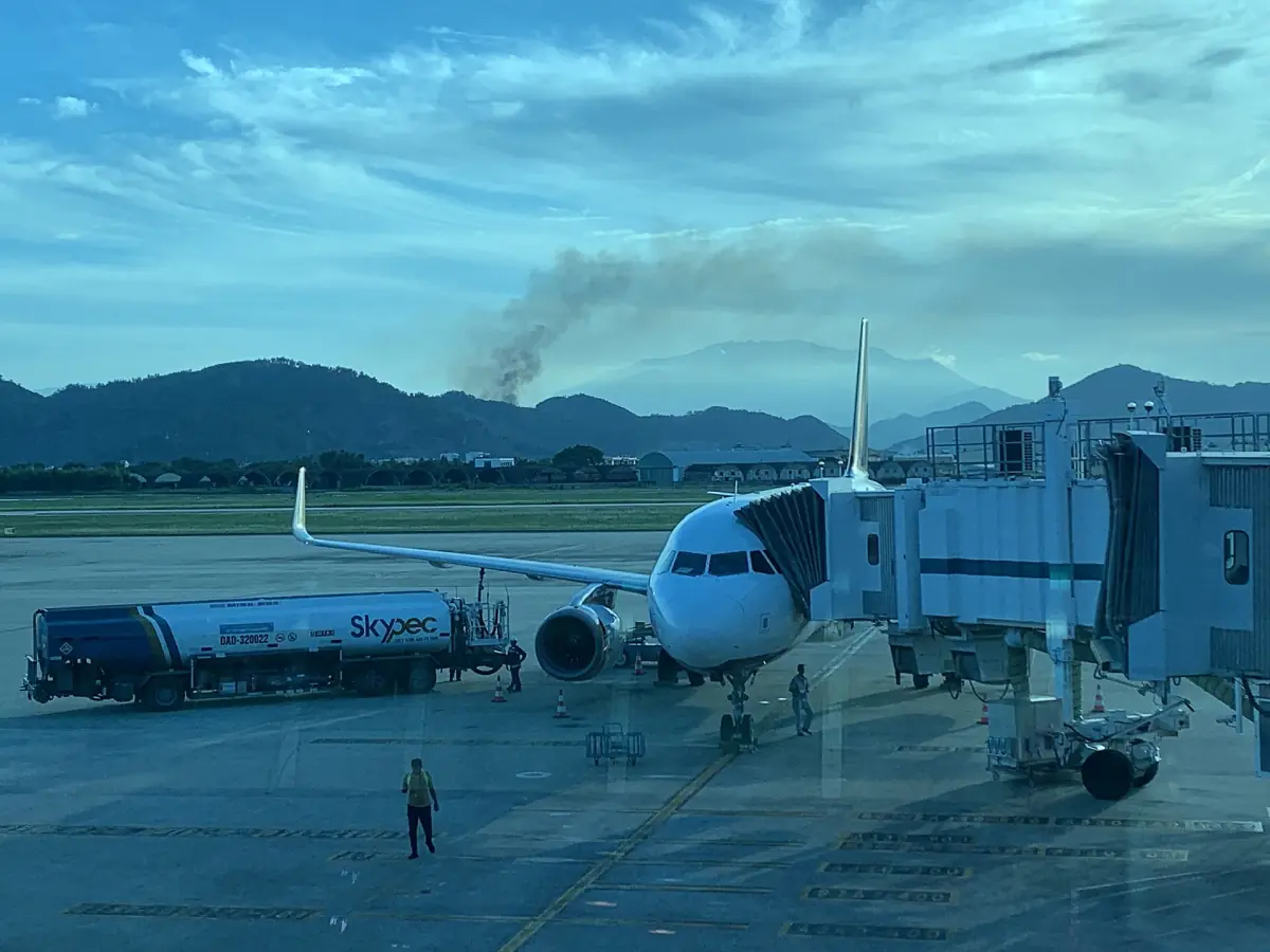 Passenger aircraft at a terminal gate with mountains behind