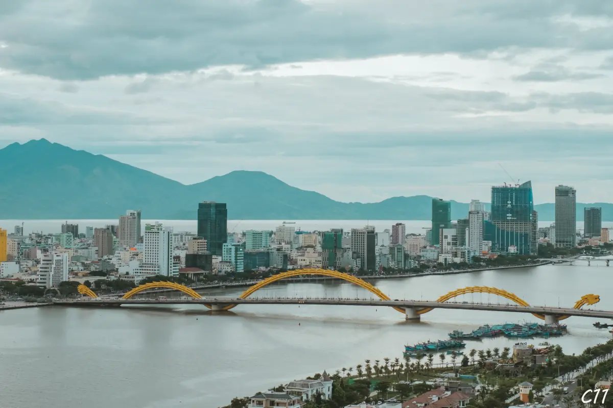 Da Nang skyline with the golden dragon bridge and mountains behind