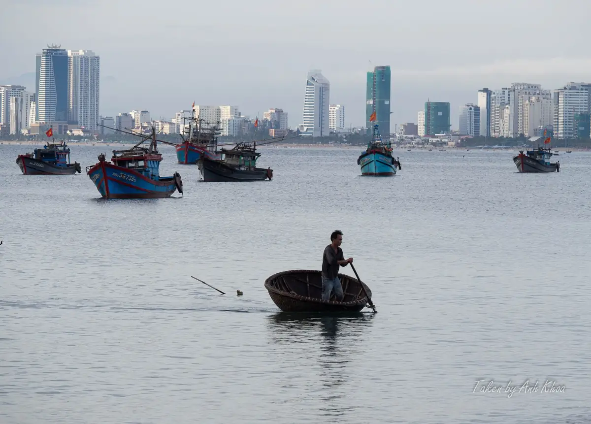 Da Nang high-rises across the water with small fishing boats in front