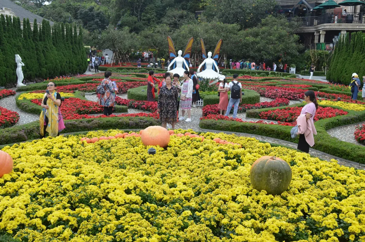 Colourful flower beds with white sculptures in a hillside garden