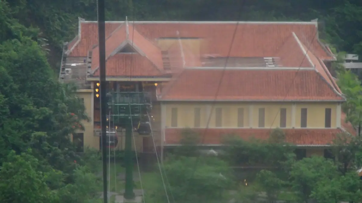 Mountain station building with red tiled roof among trees